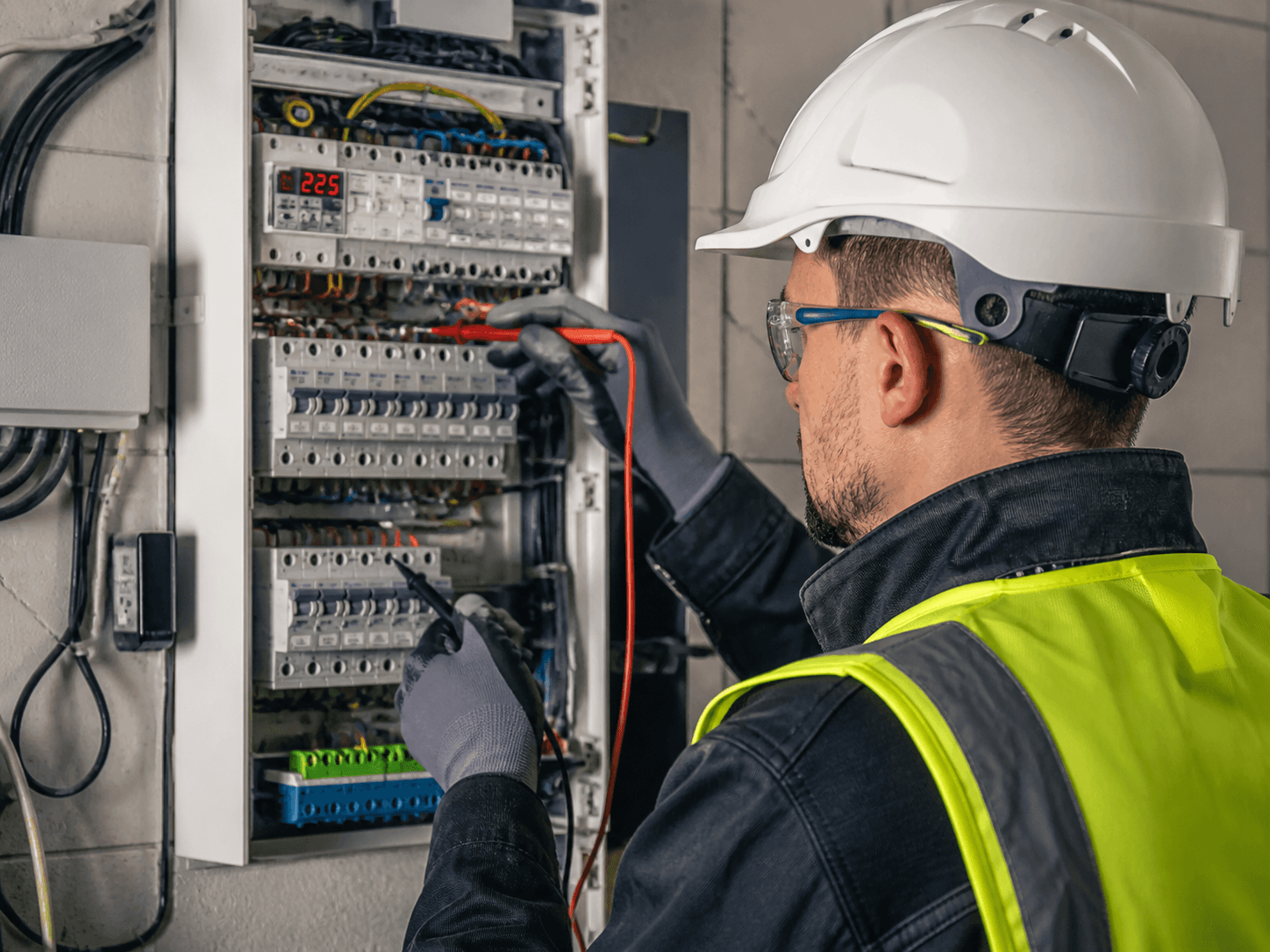 Een monteur configureert een Cerbo GX bij een woninginstallatie — werkinstructies onderweg beschikbaar in eigen taal.